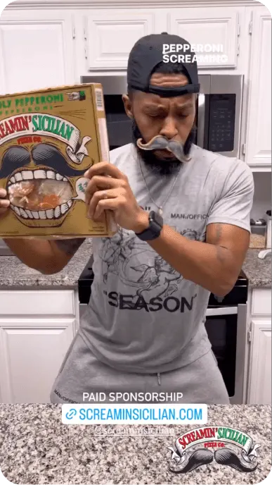 Instagram Reel still of a creator in fake mustache dances with a box of Palermos Screamin Sicilian pizza